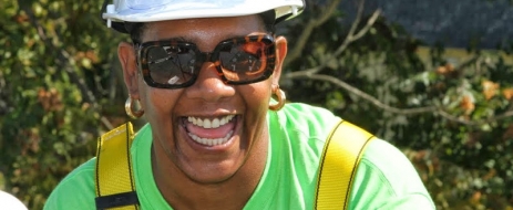 Jolyn Bright, a laughing Black woman in a hard hat and sunglasses