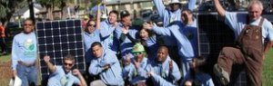 GRID Headquarters staff have fun in front of some solar panels