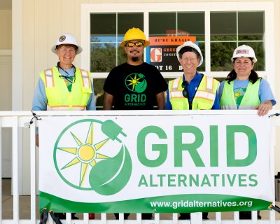 Dry Creek Rancheria Band of Pomo Indians member at center surrounded by GRID Alternatives North Coast team members, Cora Saxton, regional director and Kelsey Radmilovich, outreach manager