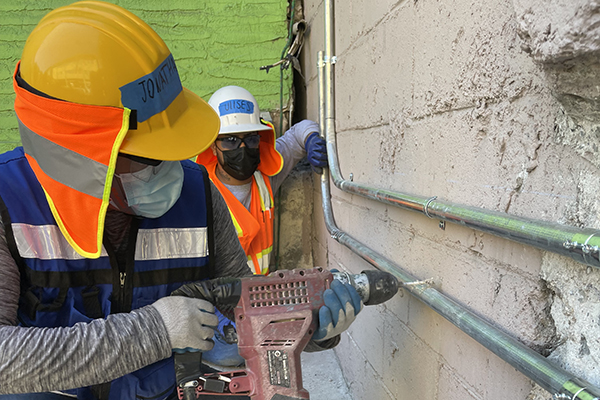 Trainees installing conduit