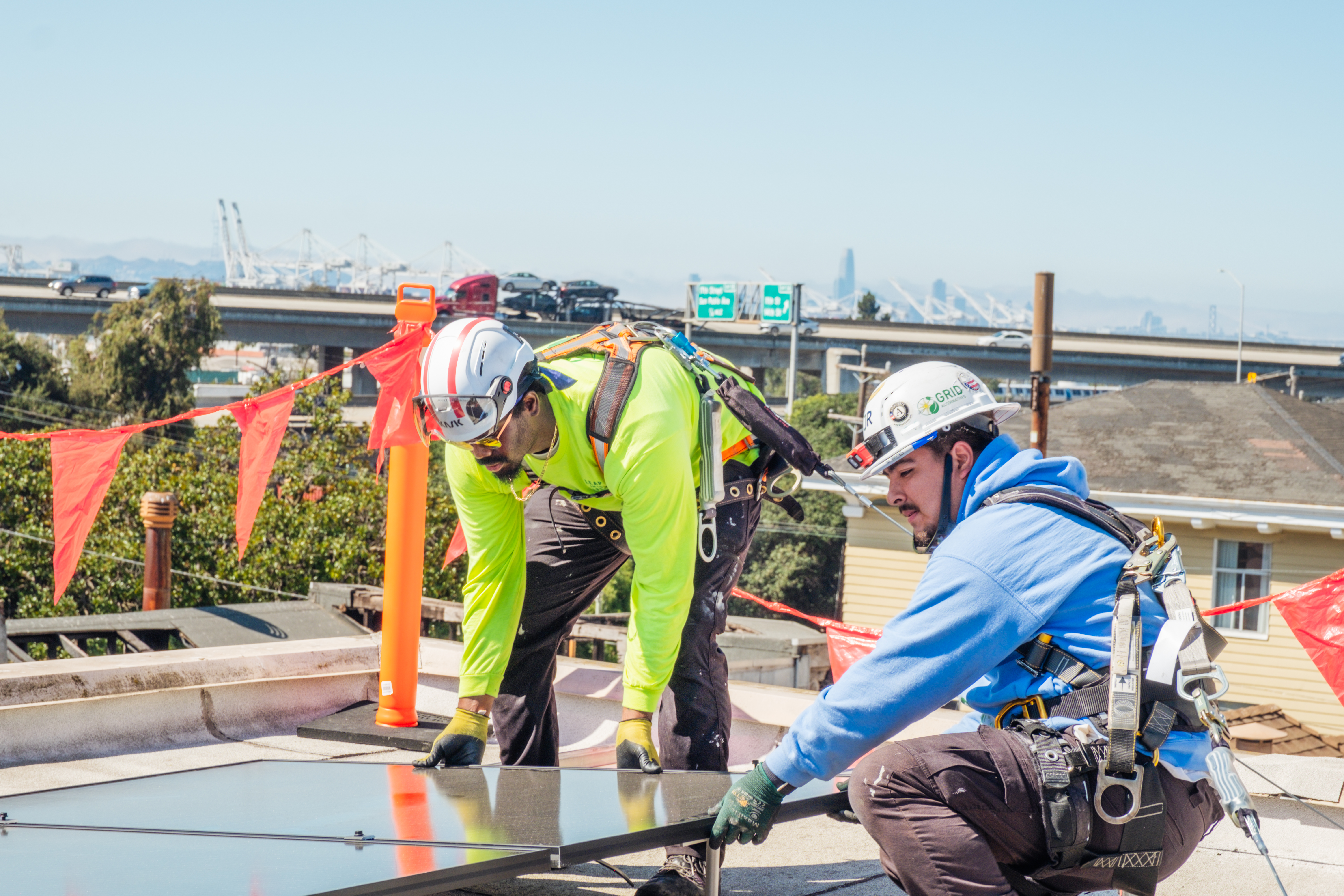 GRID installers lay a solar panel in place on the roof of the House of Dignity location.